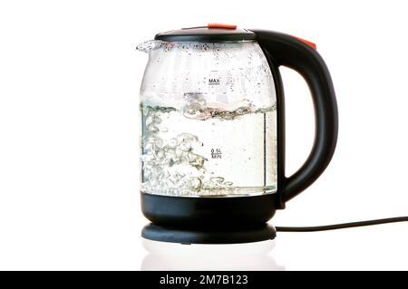 bollitore elettrico in vetro con acqua bollente su fondo bianco isolato Foto Stock