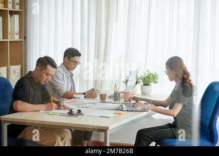Team di architetti e interior designer che lavorano insieme su un grande progetto Foto Stock