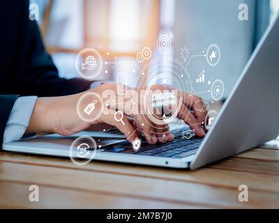 Concetto di marketing digitale e social media. Le parole con icone di strategia vengono visualizzate mentre le persone utilizzano il notebook. Soluzione di dati di affari, seo, soddisfare, advertis Foto Stock