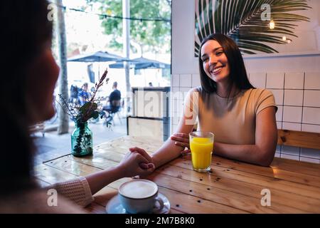 donna ama la data con un amico in una caffetteria Foto Stock