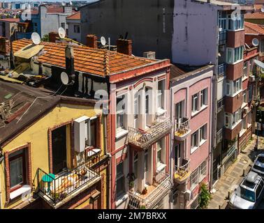 Vista dall'alto del quartiere storico di Rasimpaşa a Kadikoy, Istanbul, Turchia. Una donna che prende il sole sul balcone durante le calde giornate estive. Foto Stock