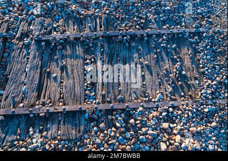 Primo piano di una passerella in legno sulla spiaggia di ciottoli a Rye Harbour, Regno Unito Foto Stock