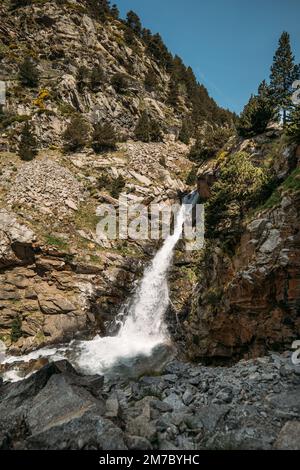 Piccolo fiume di montagna nella valle di Vall de Nuria Spagna sta guadagnando forza in cima ai Pirenei. Il canale dell'acqua fredda trasparente si sposta verso il basso Foto Stock