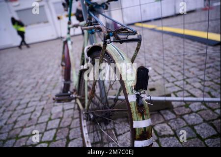 Berlino, Germania. 09th Jan, 2023. Una bicicletta abbandonata è parcheggiata su un recinto di costruzione di fronte alla stazione ferroviaria principale. Sulla ruota anteriore è allegata una nota gialla dell'ufficio dell'ordine pubblico. L'avviso indica che la bicicletta è stata abbandonata per molto tempo e al proprietario viene chiesto di rimuoverla. Dopo un periodo di tre settimane viene ceduto all'associazione Goldnetz. L'ufficio ordini effettua la pulizia di Capodanno presso la stazione centrale. Credit: Annette Riedl/dpa/Alamy Live News Foto Stock