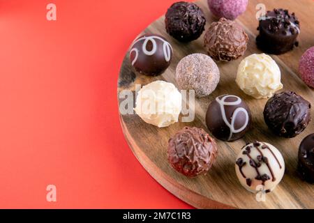 cioccolatini fotografici su un asse di legno giacente in fila Foto Stock