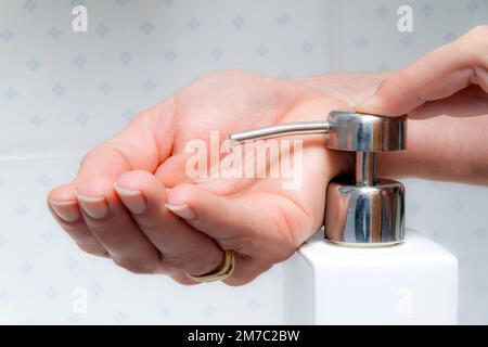 La donna lava le mani sotto acqua corrente e sapone Foto Stock