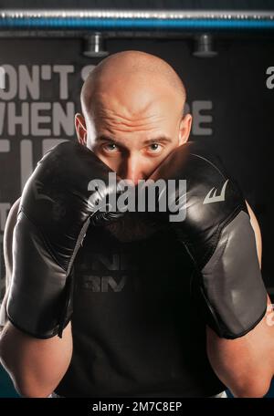gli uomini in guanti di boxe nascondono il viso dietro i guanti Foto Stock