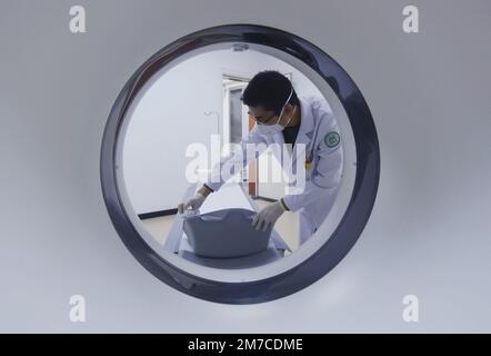 HANGZHOU, CINA - 9 GENNAIO 2023 - Un radiologo presso un centro di assistenza sanitaria della comunità disinfetta il luogo in cui le persone giacciono sulle spalle con l'alcova Foto Stock