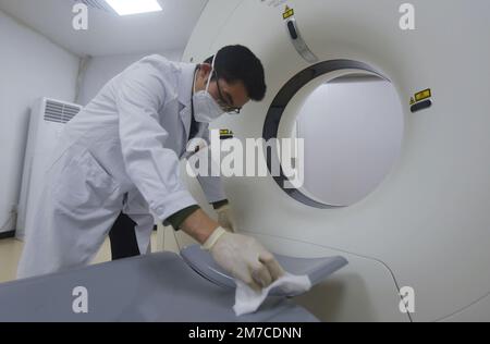 HANGZHOU, CINA - 9 GENNAIO 2023 - Un radiologo presso un centro di assistenza sanitaria della comunità disinfetta il luogo in cui le persone giacciono sulle spalle con l'alcova Foto Stock