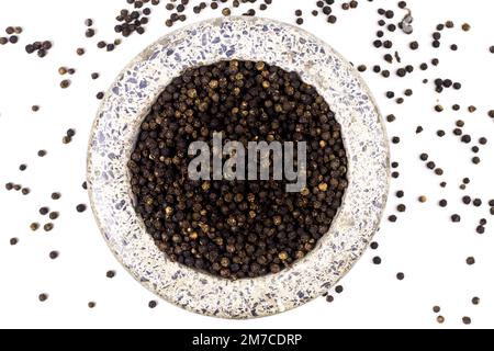 pepe nero con malta di pietra bianca isolato su fondo bianco. Pepe nero secco. Malta di pietra fatta a mano mortaio. Pietra vecchio mortaio che è stato usato per un lo Foto Stock