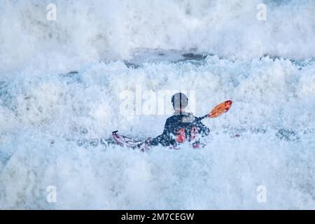 Uomo in kayak in mari pesanti Foto Stock