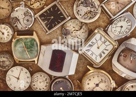 Immagine in stile retrò di una collezione di orologi e parti arrugginite d'epoca