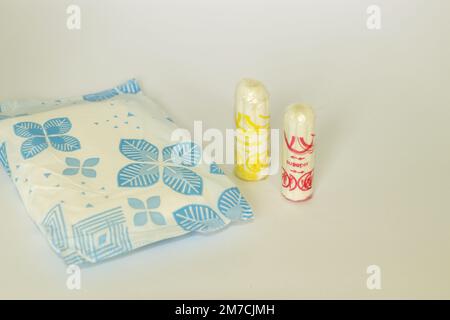 2 tamponi e 1 assorbente igienico/ tampone in piedi su uno sfondo bianco isolato con un concetto di un periodo o prodotti per l'igiene mestruale Foto Stock