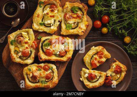 Crostate croccanti di pasta sfoglia con zucchine, pomodori e formaggio. Foto Stock