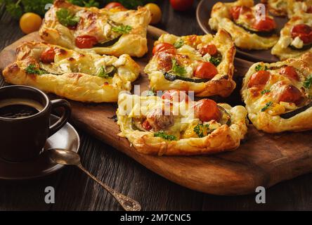 Crostate croccanti di pasta sfoglia con zucchine, pomodori e formaggio. Foto Stock