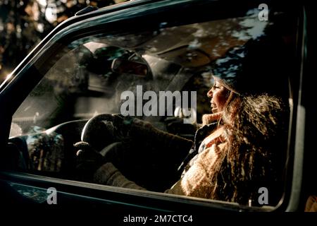 Vista laterale di una giovane donna felice che guida un veicolo fuoristrada visto attraverso il vetro Foto Stock