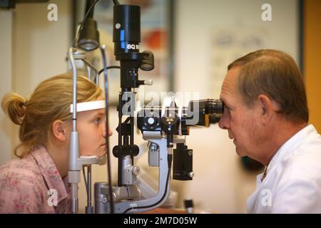 Optometristo che esegue test della vista per la paziente ragazza in clinica Foto Stock