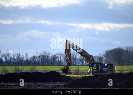 Magdeburgo, Germania. 09th Jan, 2023. Un escavatore sposta la terra in un campo. Il produttore di chip Intel desidera costruire un impianto sul campo nella periferia di Magdeburgo. Il produttore statunitense di chip ha ora ribadito il proprio impegno nei piani di investimento a Magdeburgo. Si lavora insieme al governo tedesco per portarlo al successo. Nel marzo 2022, Intel aveva annunciato che l'ultima generazione di chip sarebbe stata prodotta a Magdeburgo a partire dal 2027. Due impianti a semiconduttore devono essere costruiti in una fase iniziale di espansione. Credit: Klaus-Dietmar Gabbert/dpa/Alamy Live News Foto Stock