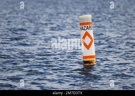 Pericolo boa di sicurezza che allerta i navigatori al pericolo di navigazione. Avvertenza nautica galleggiante di attenzione. Foto Stock