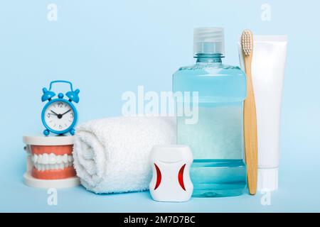 Collutorio e altri prodotti per l'igiene orale sulla vista dall'alto del tavolo a colori con spazio per la copia. Disposizione piatta. Igiene dentale. Kit per la cura orale. Concetto di dentista. Foto Stock