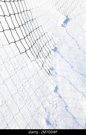 Auto tracce di pneumatici a sinistra in un profondo strato di neve creando un modello astratto come un fiume tortuoso attraverso la campagna. Foto Stock