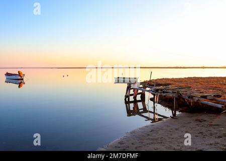 barche da pesca in barca a vela, vista da un vecchio molo al tramonto Foto Stock