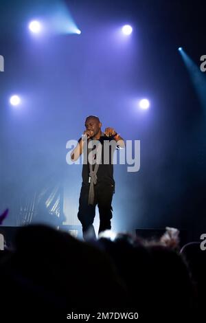 rapper sul palco con luci bianche sullo sfondo Foto Stock