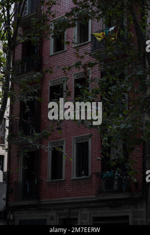 Una foto verticale di un edificio di appartamenti con muro di mattoni rossi Foto Stock