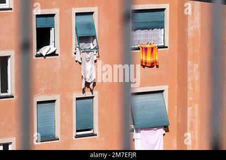 Lavaggio appeso a balconi e finestre in una città italiana asciugandosi al sole. Foto Stock