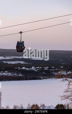 Beautiful ski slope in Funasdalen, Sweden with ski lift, gondola going up the hill surrounded by forest on a sunny winter day. Skiing resort in Sweden Foto Stock