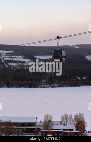 Beautiful ski slope in Funasdalen, Sweden with ski lift, gondola going up the hill surrounded by forest on a sunny winter day. Skiing resort in Sweden Foto Stock