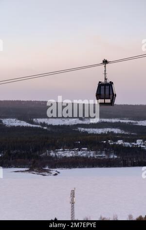 Beautiful ski slope in Funasdalen, Sweden with ski lift, gondola going up the hill surrounded by forest on a sunny winter day. Skiing resort in Sweden Foto Stock