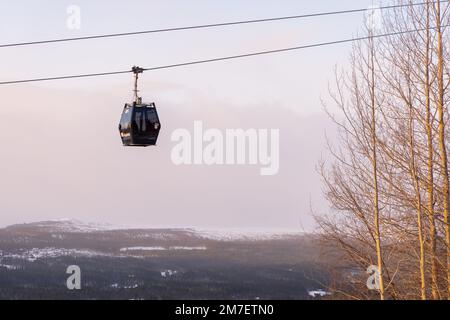 Beautiful ski slope in Funasdalen, Sweden with ski lift, gondola going up the hill surrounded by forest on a sunny winter day. Skiing resort in Sweden Foto Stock