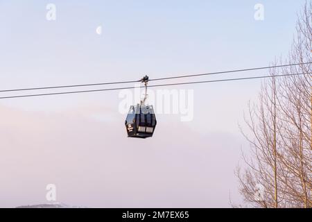 Beautiful ski slope in Funasdalen, Sweden with ski lift, gondola going up the hill surrounded by forest on a sunny winter day. Skiing resort in Sweden Foto Stock
