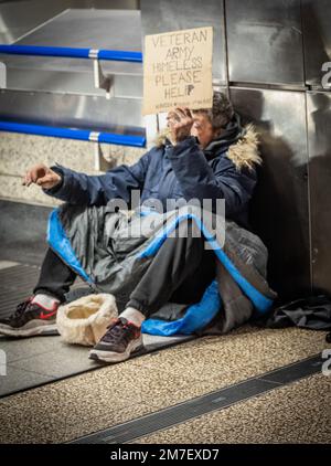 Un veterano senza casa si mendica all'ingresso della stazione Victoria di Londra mentre i ministri del Regno Unito si sono impegnati a porre fine al sonno duro tra i veterani militari il prossimo anno Foto Stock