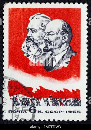 URSS - CIRCA 1965: Francobollo 6 kopeck stampato in Unione Sovietica mostra Ritratto di Karl Marx e Vladimir Lenin e persone con la bandiera rossa. Pos Foto Stock