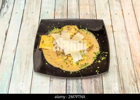 I ravioli sono una pasta italiana farcita fatta con ingredienti diversi e di solito ripiegata a forma quadrata. Foto Stock