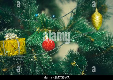 Decorazioni natalizie e luci colorate ghirlande su albero di Natale. Luci e luci luminose sullo sfondo delle decorazioni natalizie. Foto Stock