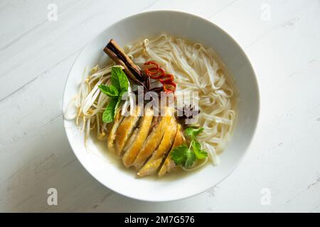 Zuppa di Pho vietnamita di pollo. Il Phở, spesso scritto come pho, è un piatto tradizionale vietnamita basato su quella che viene genericamente chiamata zuppa di noodle. Foto Stock