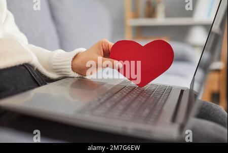 Giovane donna sta utilizzando un computer portatile e alla ricerca di amore su un sito web di incontri Foto Stock