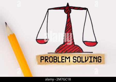 Concetto giuridico. Accanto alle scale di giustizia dipinte si trovano una matita e una striscia di carta con l'iscrizione - PROBLEM SOLVING Foto Stock