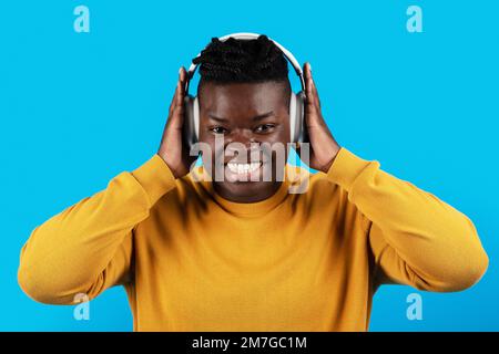 Happy Young African American Man ascoltare musica in cuffie wireless Foto Stock