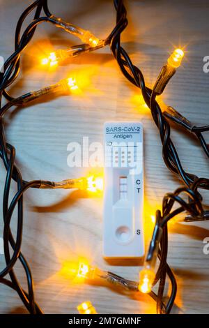 Test corona positivo con luci natalizie sullo sfondo Foto Stock