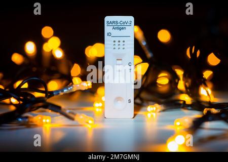 Test corona positivo con luci natalizie sullo sfondo Foto Stock