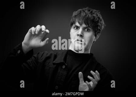 pazzo giovane uomo con capelli impressionante grimacing Foto Stock