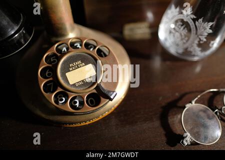 Base di un primo 1900s Western elettrico Ottone Bullnose Candlestick Rotary Dial Telefono con si prega di attendere la scritta del tono di composizione sulla composizione del numero. Foto Stock