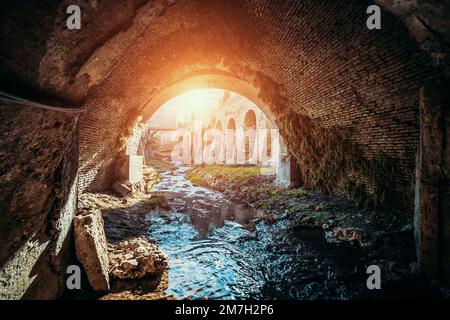 Vista dall'interno del tunnel fognario, vecchio tunnel per il fiume o fognature con luce solare. Foto Stock