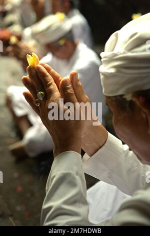 Un clan balinese sta pregando insieme durante un rituale per onorare e purificare gli spiriti dei loro ultimi membri della famiglia, in un tempio situato nel complesso del tempio di Besakih, sul pendio del Monte Agung a Karangasem, Bali, Indonesia. Foto Stock