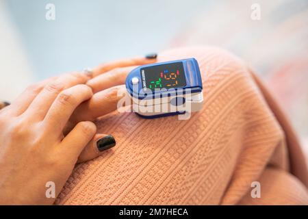 Primo piano dito del paziente che osserva e verifica dell'ossigeno nel sangue Foto Stock