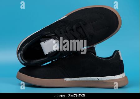 Coppia di scarpe casual nere vista laterale e dall'alto isolate su sfondo blu studio Foto Stock